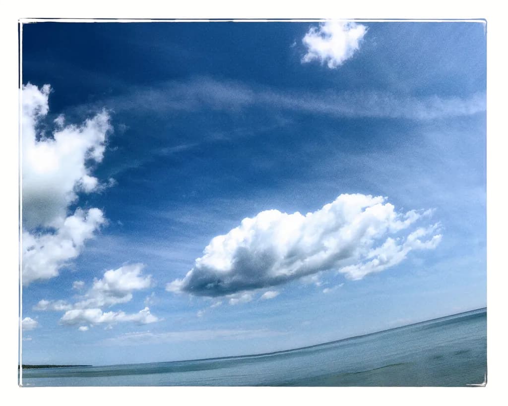 Serenity Above: A Tranquil Dance of Clouds and Water in Blue Skies