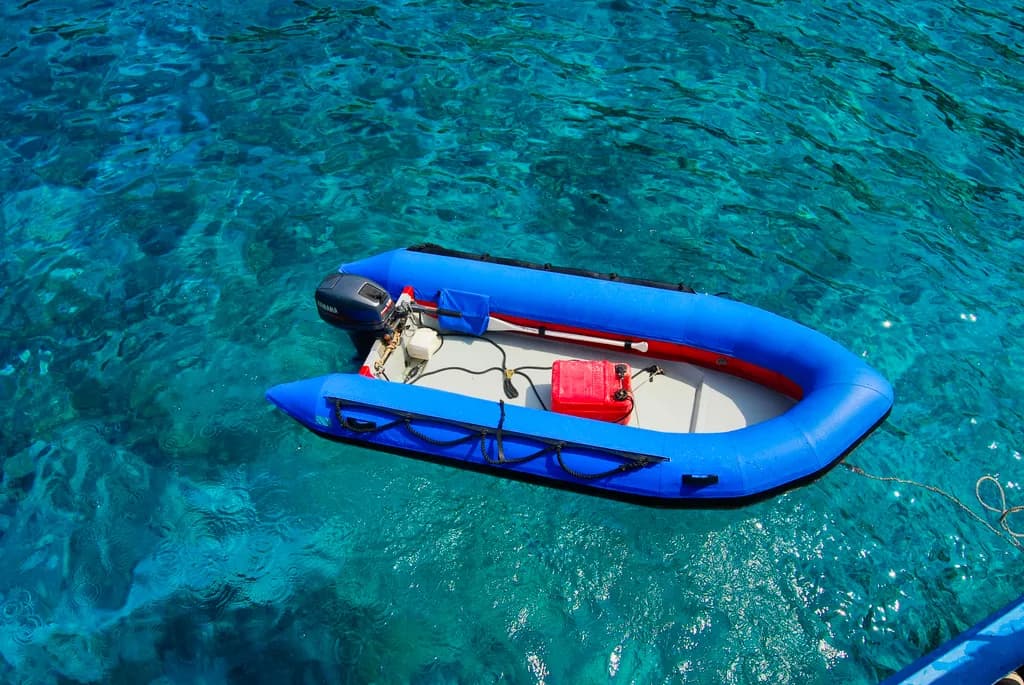 Serenity on the Surface: A Vibrant Blue Boat Adrift in Crystal Waters