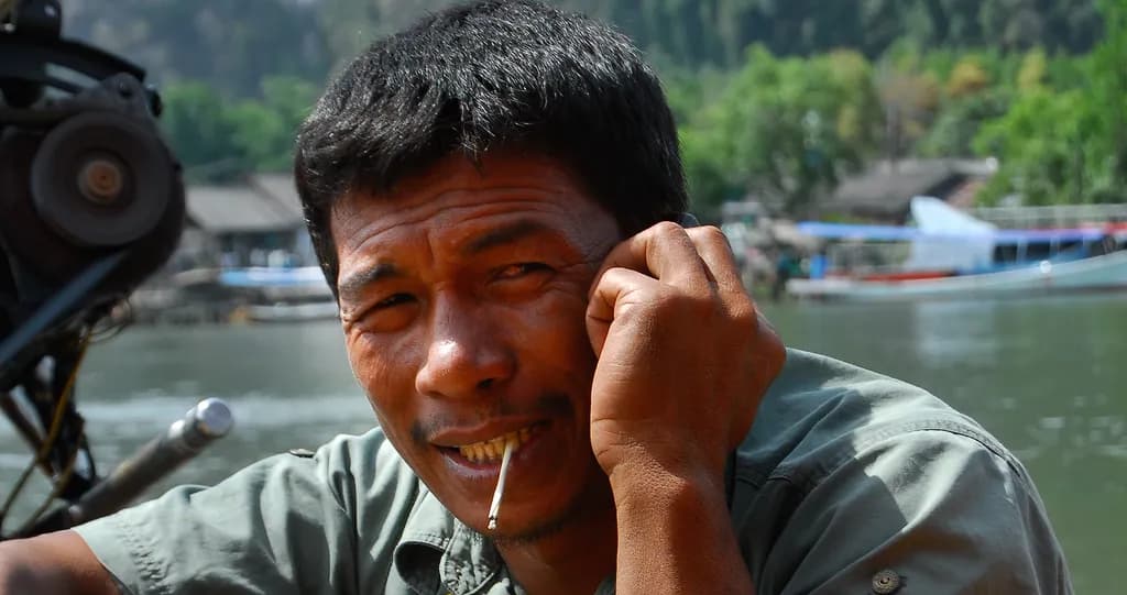A Glimpse of Resilience: The Fisherman's Smile by the Water's Edge