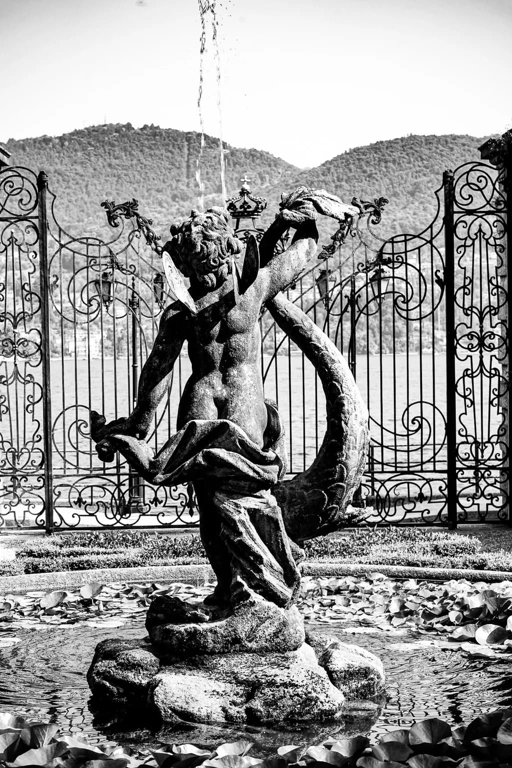 Ethereal Dance of the Fountain: A Serene Black and White Sculpture Amidst Nature's Embrace