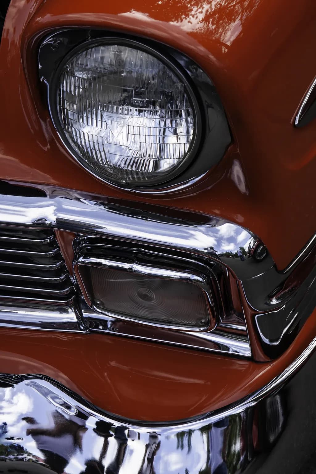 Classic Chrome Elegance: A Vintage Car's Radiant Headlight in Orange Splendor