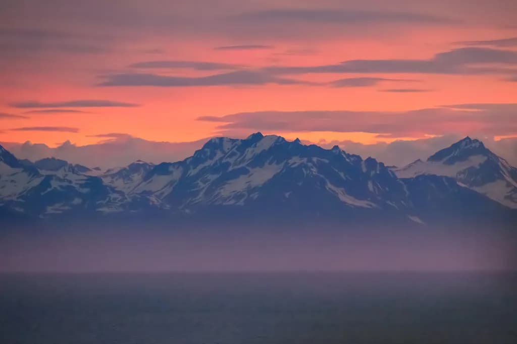 Whispers of Dusk: Majestic Mountains Embraced by a Serene Sunset