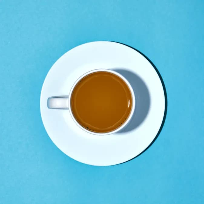 Serenity in a Cup: A Top-View Exploration of Coffee's Warm Embrace on a Blue Canvas