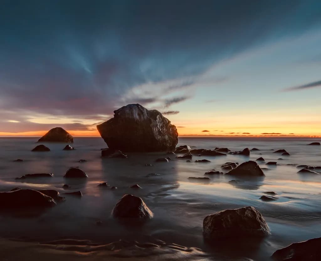 Serenity at Dusk: A Tranquil Seascape with Majestic Rocks and Gentle Waves