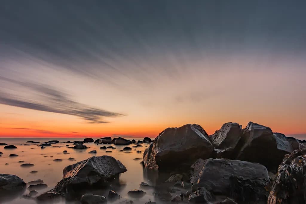 Serene Sunset Over Rocky Waters: A Tranquil Landscape Experience