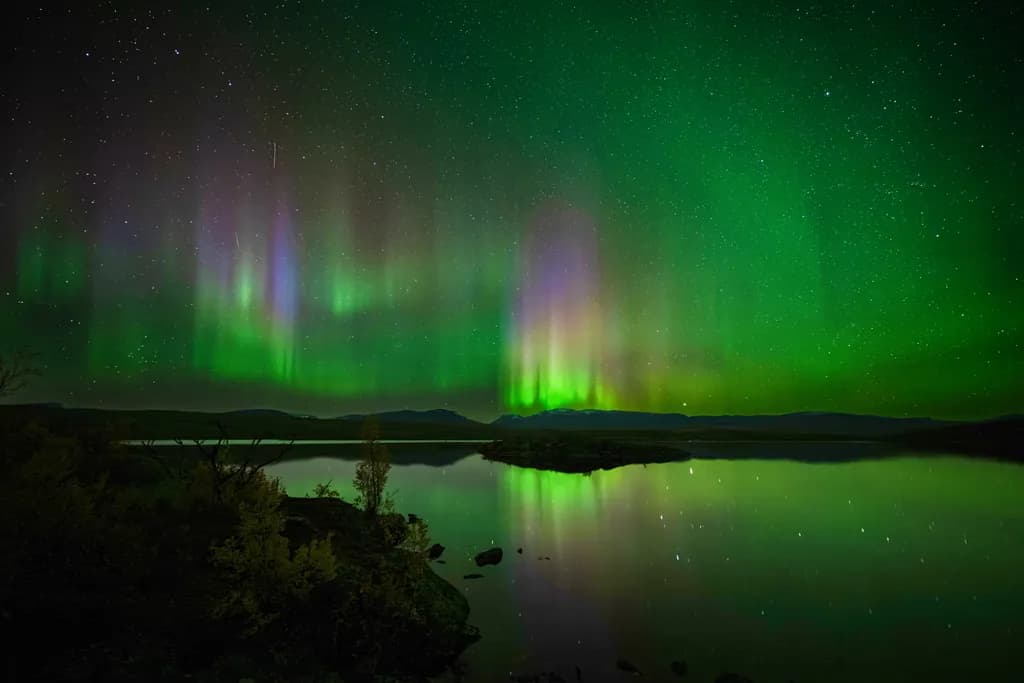 Whispers of the Aurora: A Night's Reflection in Green and Stars