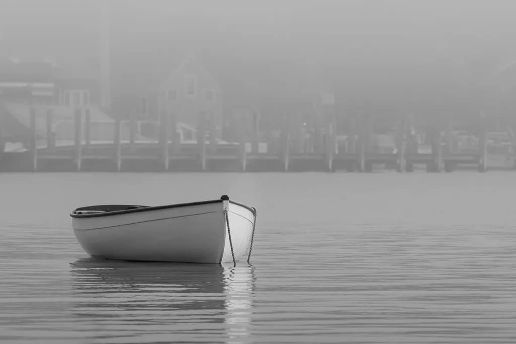 Whispers of Solitude: A Boat's Journey Through the Misty Embrace of Dawn