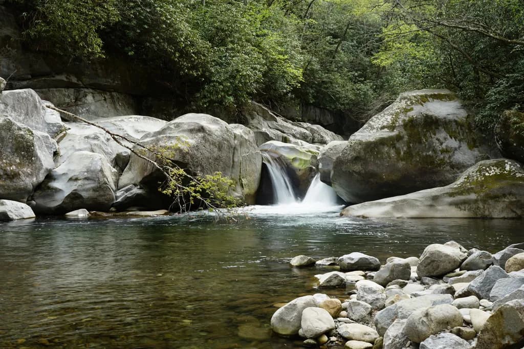 Serenity in Nature: A Tranquil Waterfall Amidst Majestic Rocks and Lush Forests
