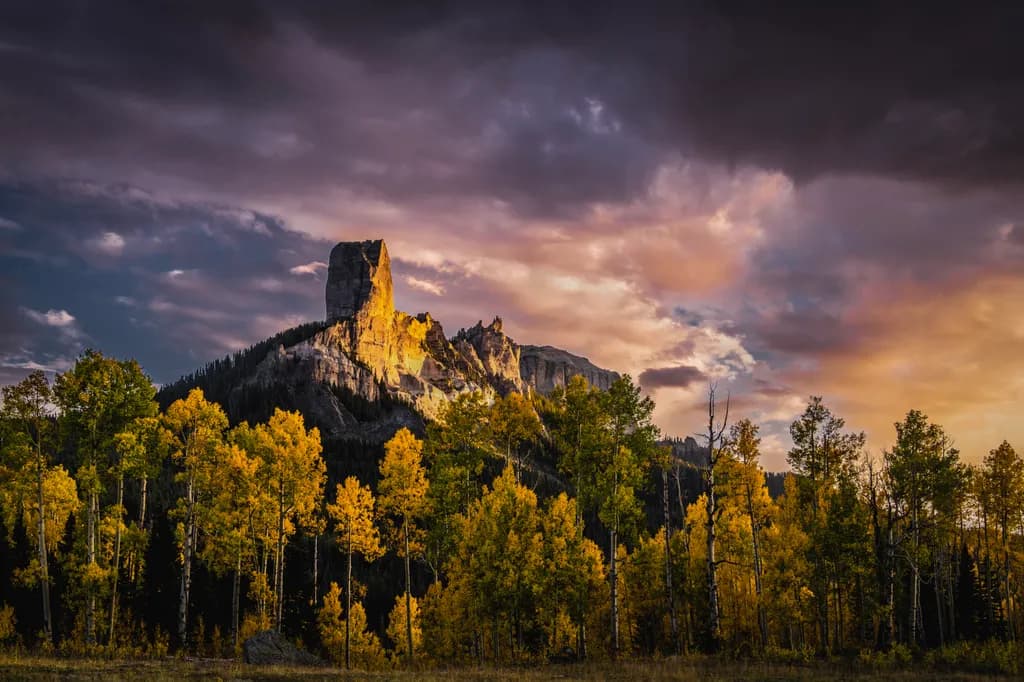 Majestic Peaks: Autumn's Embrace in Golden Aspens and Dramatic Skies