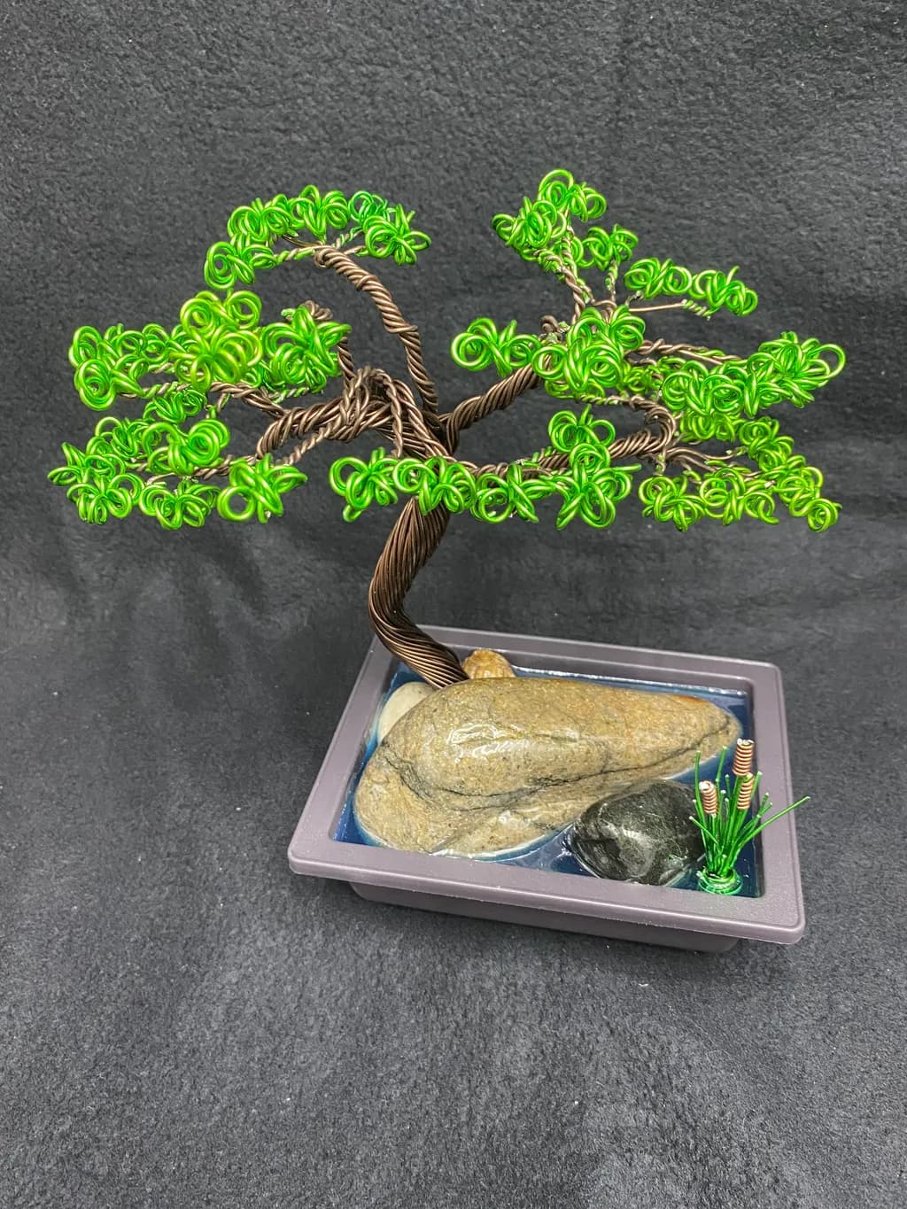 Whimsical Wire Bonsai: A Lush Green Tree Sculpture with Serene Stone Base