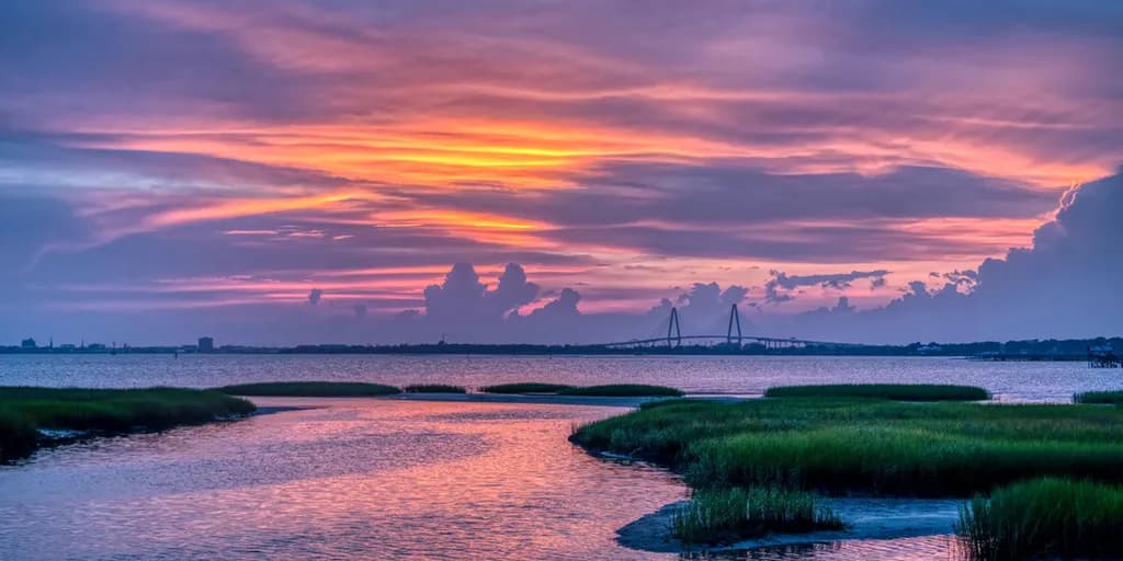 Serenity at Dusk: A Tranquil Sunset Over Water and Marshlands