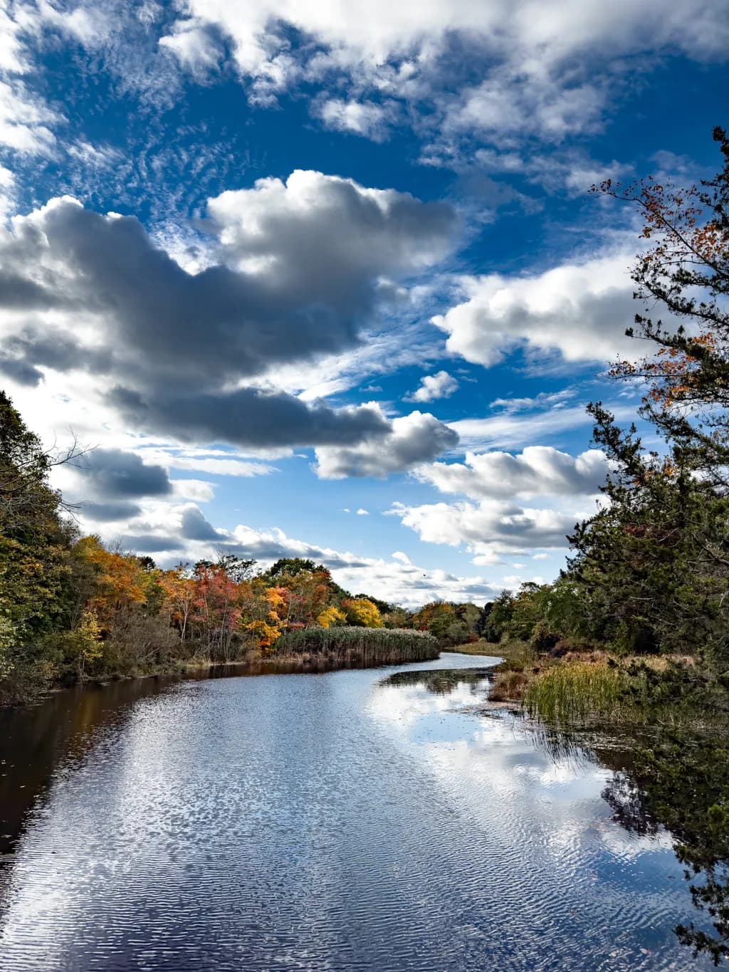 Serenity Reflected: A Tranquil Autumn River Scene Under a Vast Sky
