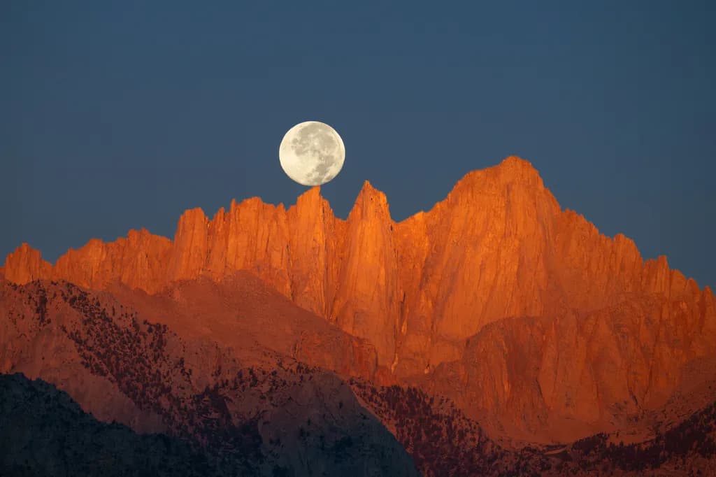 Twilight Serenade: The Moon's Embrace Over Fiery Peaks