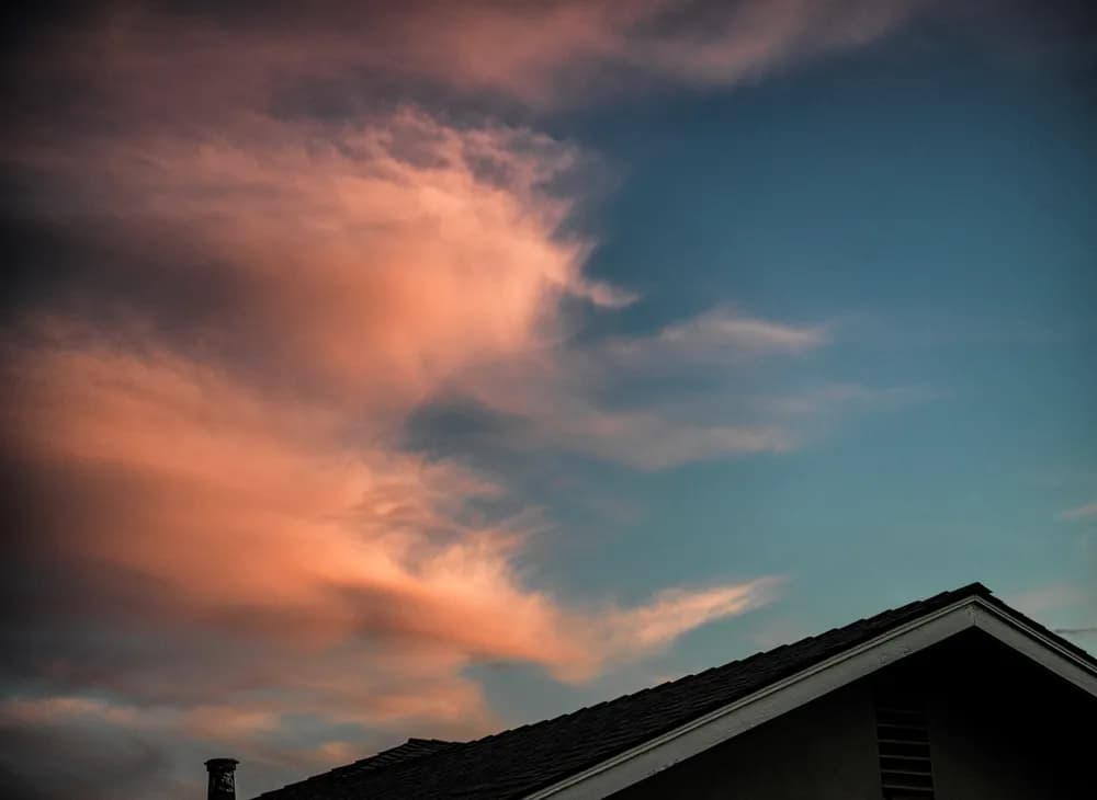 Whispers of Twilight: A Serene Evening Sky Over Rooftops