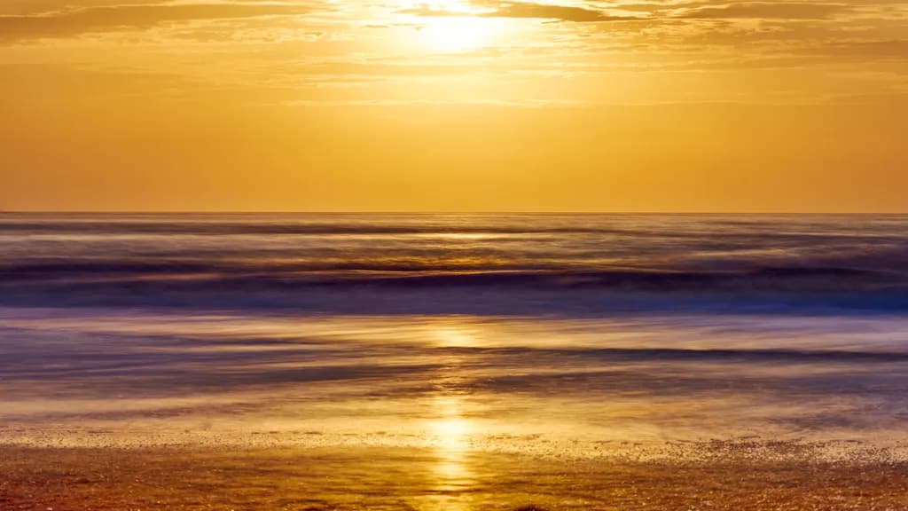 Golden Serenity: A Tranquil Sunset Over Ocean Waves
