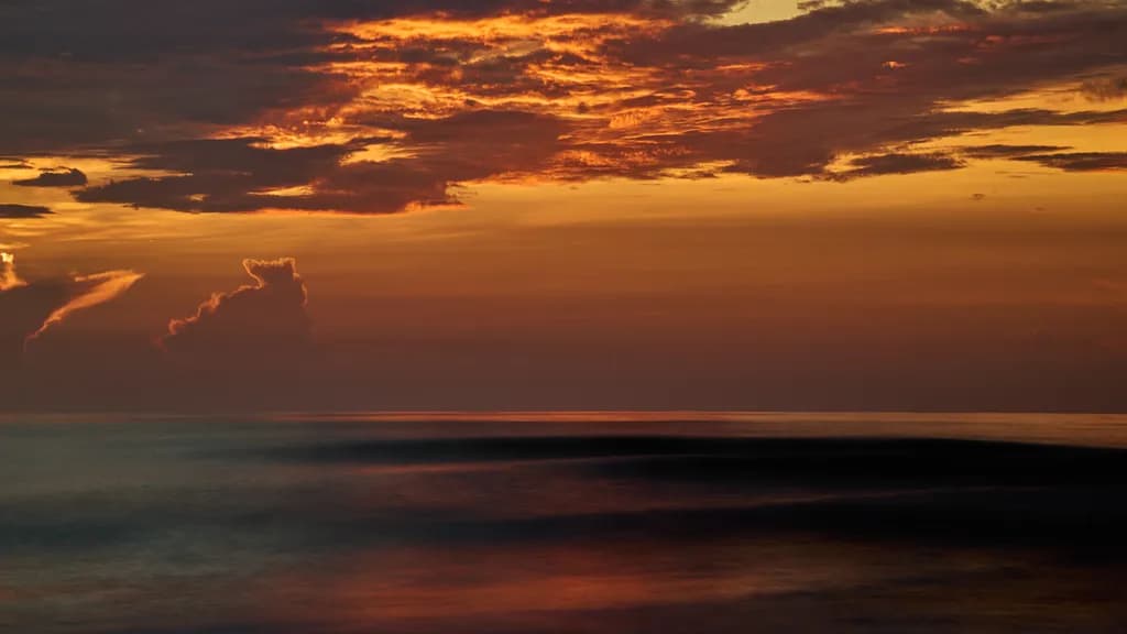 Whispers of Dusk: A Serene Ocean Sunset Embraced by Fiery Skies