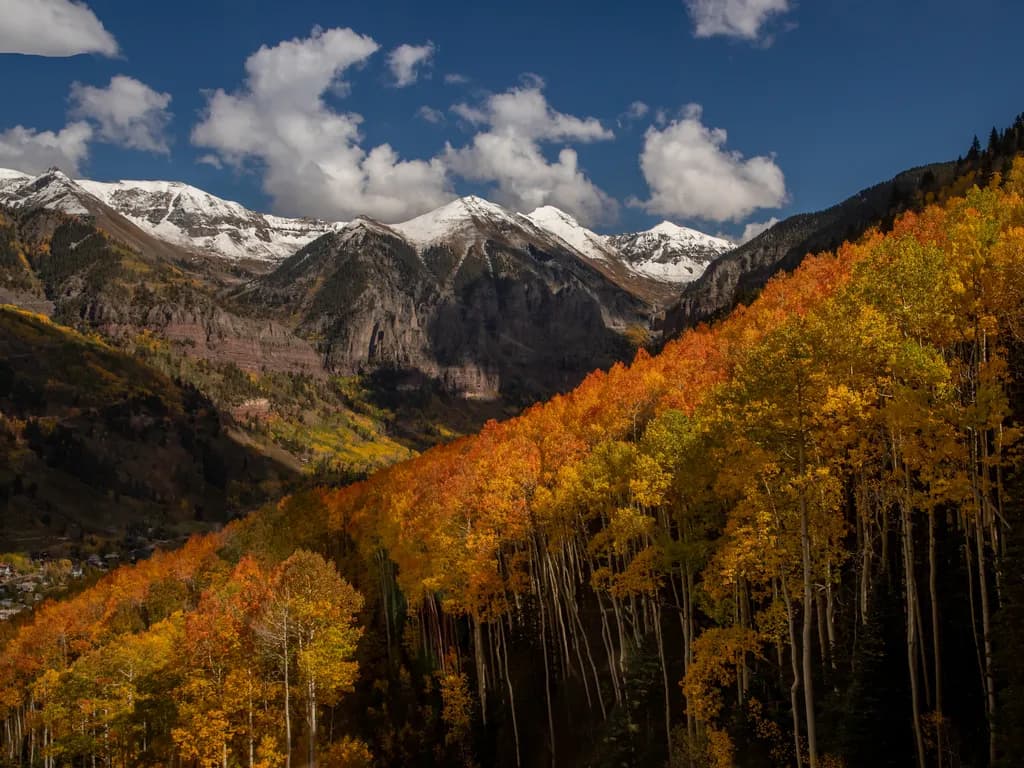 Autumn's Embrace: A Majestic Mountain Landscape Awash in Golden Hues and Snow-Capped Peaks