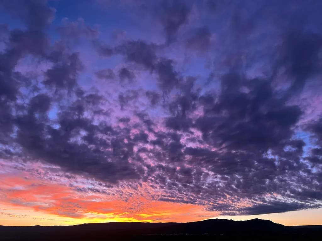 Celestial Symphony: A Vibrant Sunset Over the Horizon