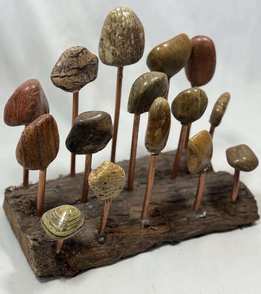 Sculptural Serenity: Polished Stones and Copper Rods Create a Tranquil Forest Display