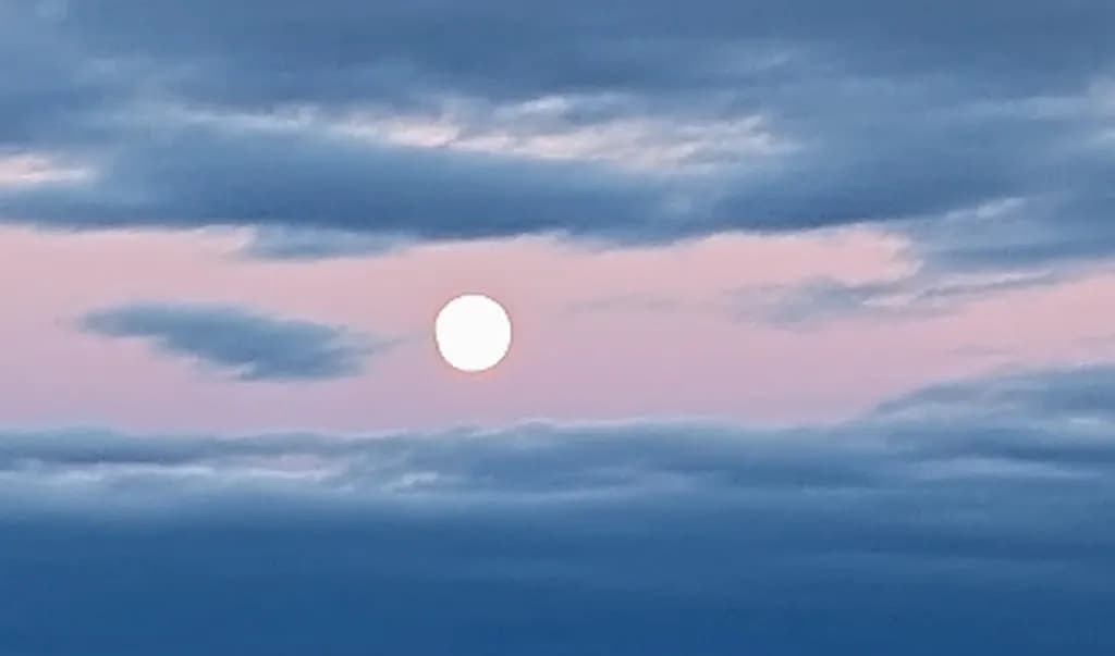 Whispers of Twilight: A Serene Moonrise Amidst Soft Clouds