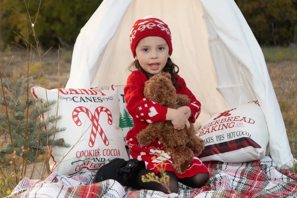Whimsical Winter Wonderland: A Cozy Child's Embrace with Teddy Bear and Holiday Cheer