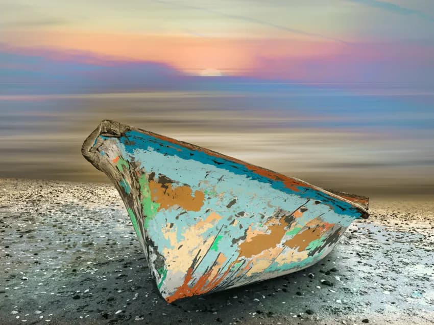 Serenity at Sunset: A Weathered Boat on the Tranquil Shoreline