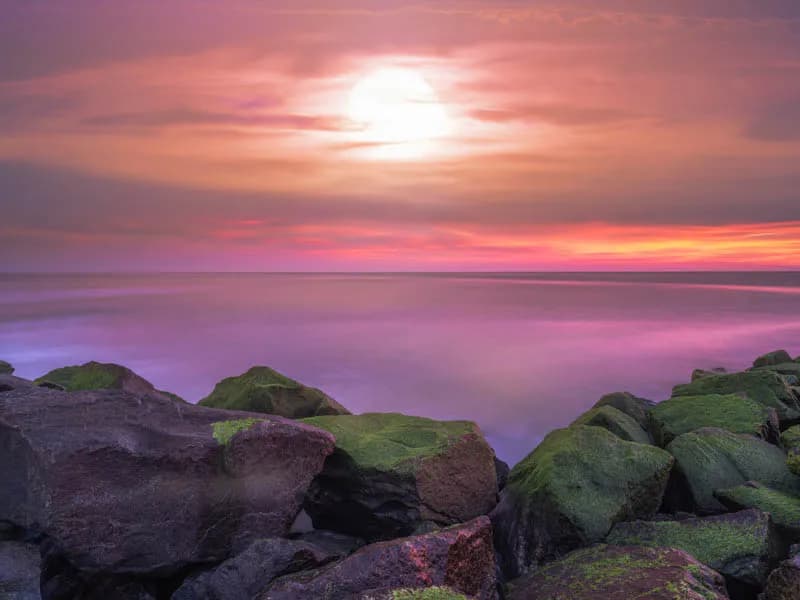 Serenity at Dusk: A Tranquil Seascape of Rocks and Sunset Hues