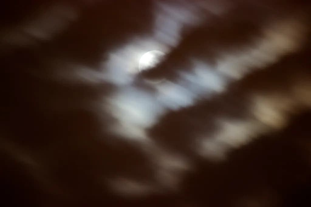 Whispers of the Moon: A Blurred Night Sky Embrace
