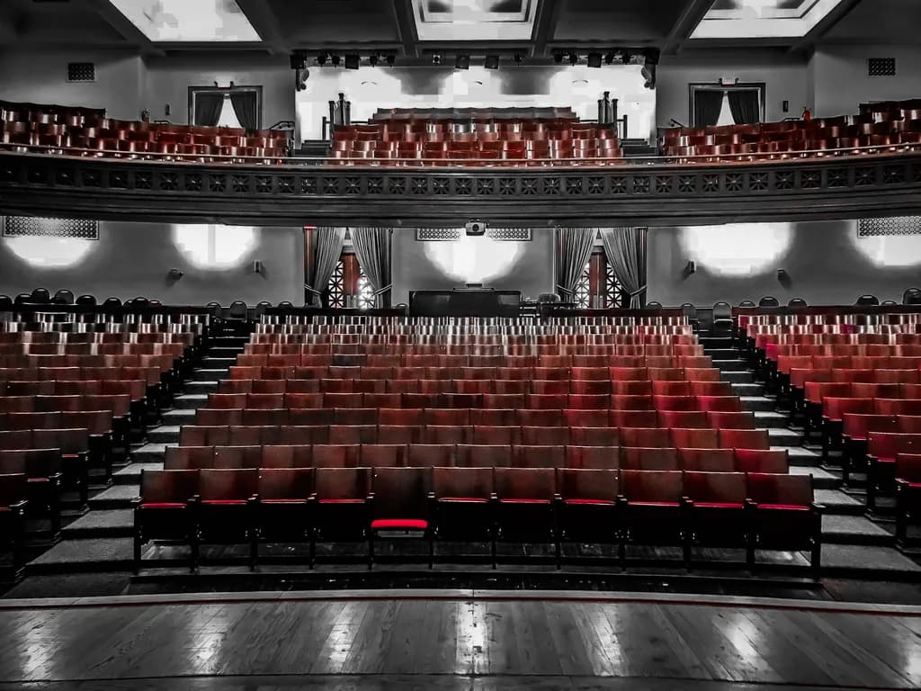 Silent Stage: A Captivating Contrast of Empty Seats and Vibrant Red
