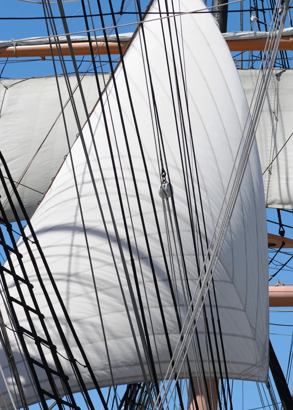 Sails of Serenity: A Nautical Dance of Ropes and Canvas Under the Blue Sky