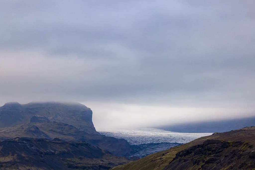 Whispers of the Glacier: A Serene Mountain Landscape Under Cloudy Skies