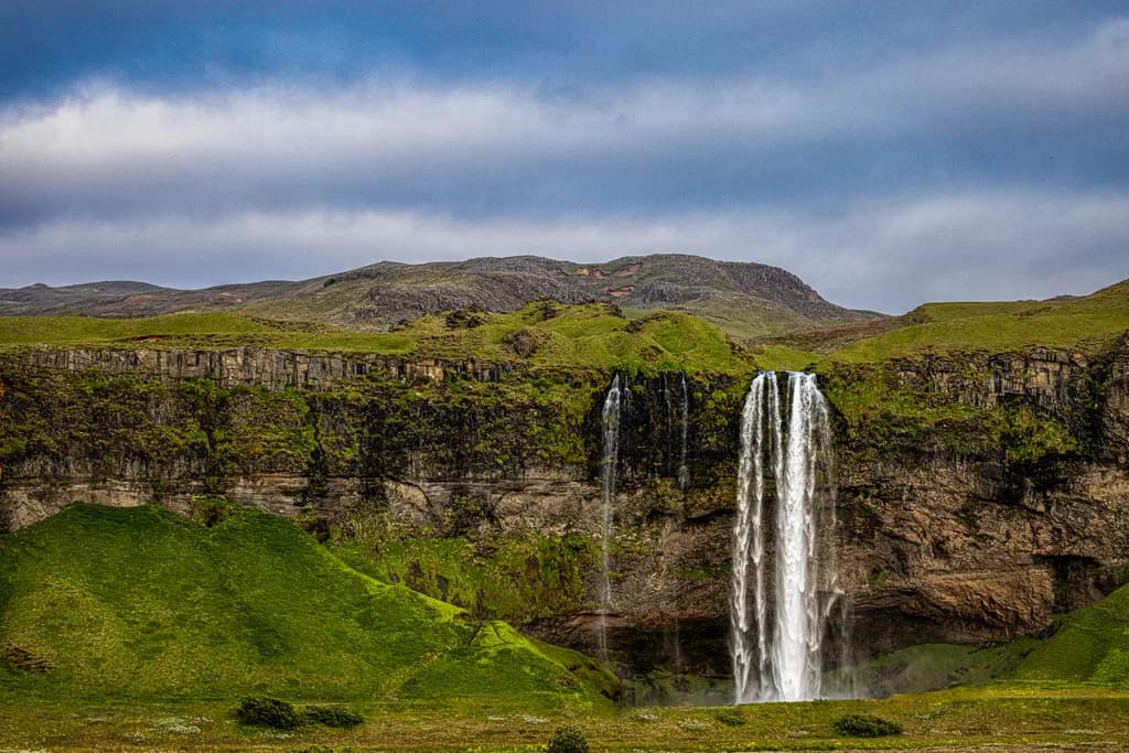 Whispers of Nature: The Majestic Seljalandsfoss Waterfall Amidst Lush Green Landscapes
