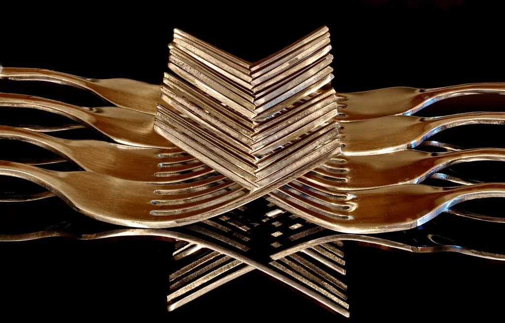 Reflections of Elegance: Stacked Metallic Forks in Artistic Harmony