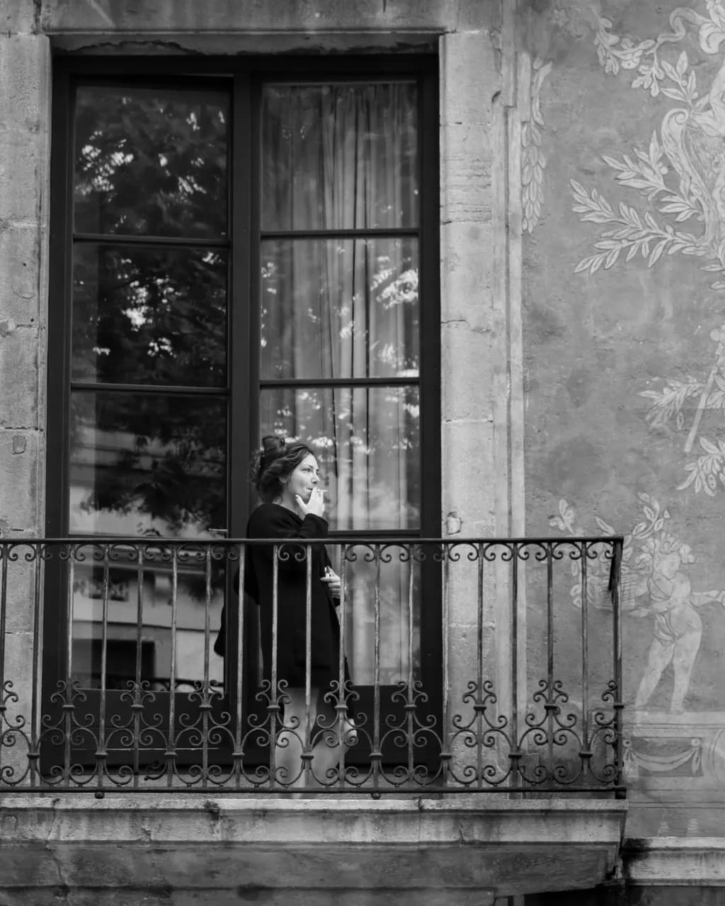 Whispers of Contemplation: A Black and White Portrait on the Balcony of Urban Life
