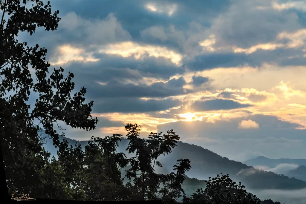 Whispers of Dawn: A Serene Mountain Sunrise Amidst the Clouds