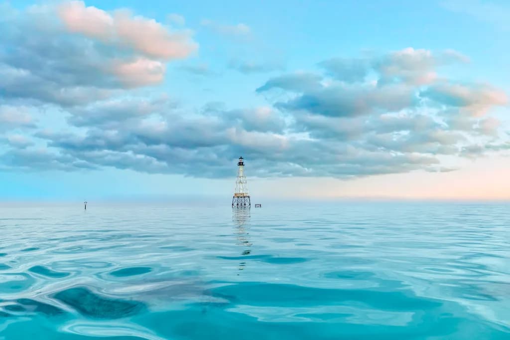 Serenity in Reflection: A Lighthouse Embraced by Tranquil Waters and Dreamy Skies