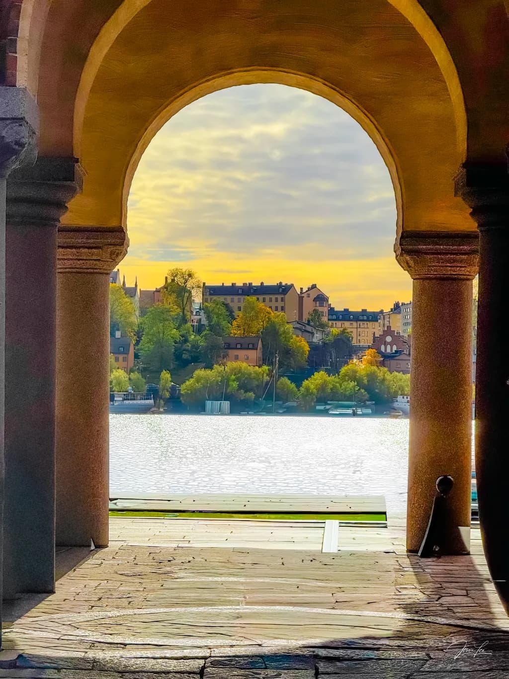 Serenity Through the Archway: A Tranquil Waterfront Reflection at Dusk