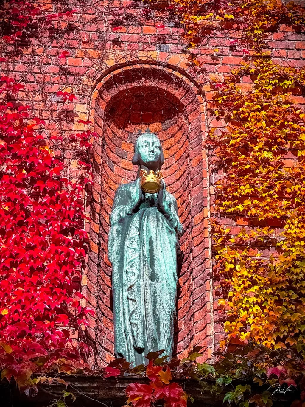 Whispers of Autumn: A Serene Statue Embraced by Nature's Colors