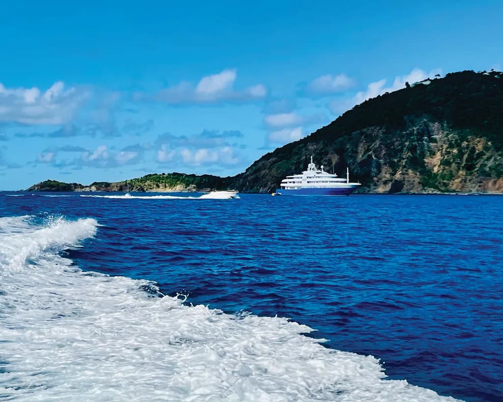 Serenity at Sea: A Majestic Yacht Anchored Against a Vibrant Coastal Backdrop