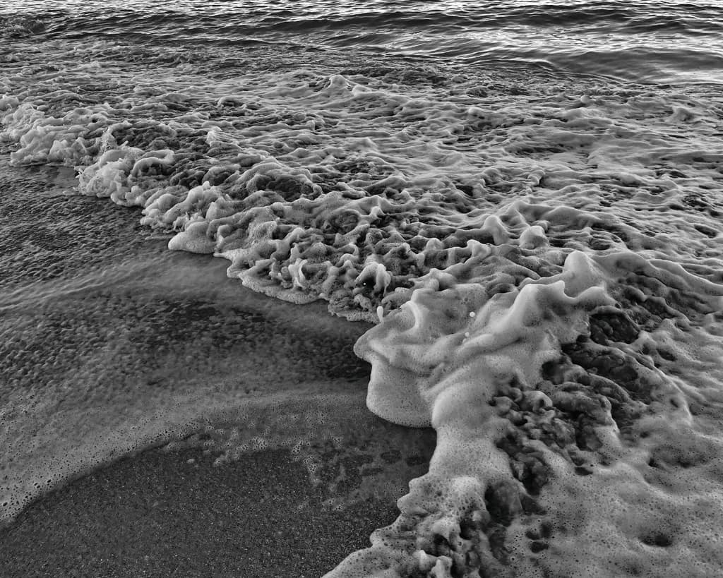 Ocean's Whisper: A Black and White Dance of Waves and Foam