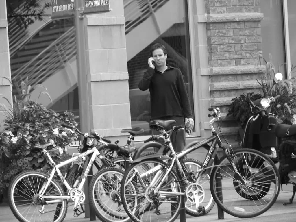 Urban Conversations: A Moment in Black and White Amidst Bicycles and City Life