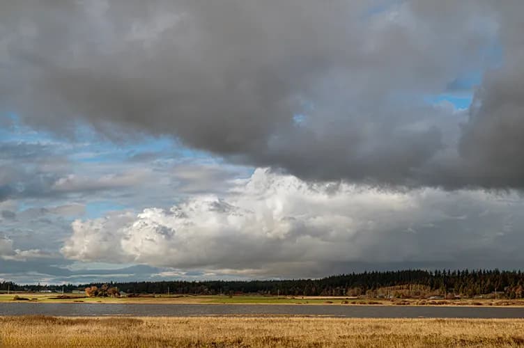 Whispers of the Sky: A Serene Landscape Under Dramatic Clouds