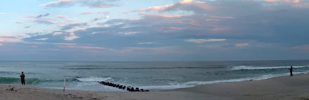 Serenity at Dusk: A Tranquil Beach Fishing Experience Under the Clouds