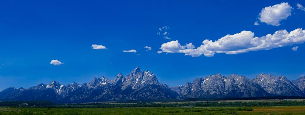Majestic Peaks Beneath a Vast Blue Sky: A Serene Mountain Landscape Experience