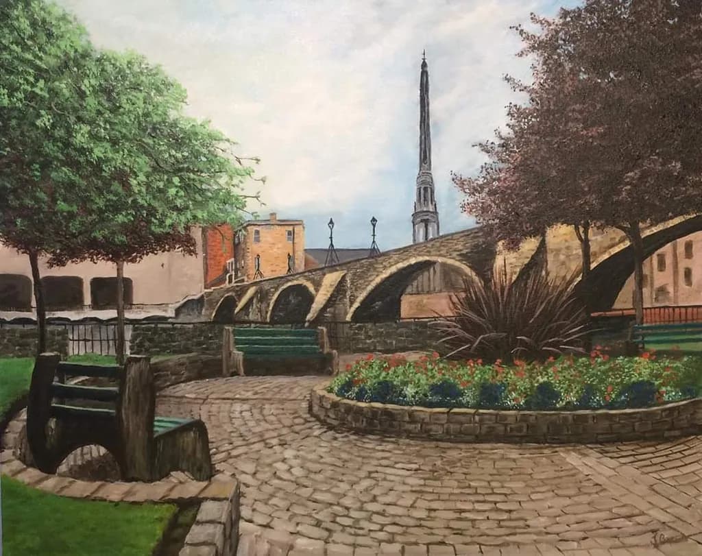 Serenity in the Park: A Tranquil Stroll by the Riverbank with Historic Bridge Views