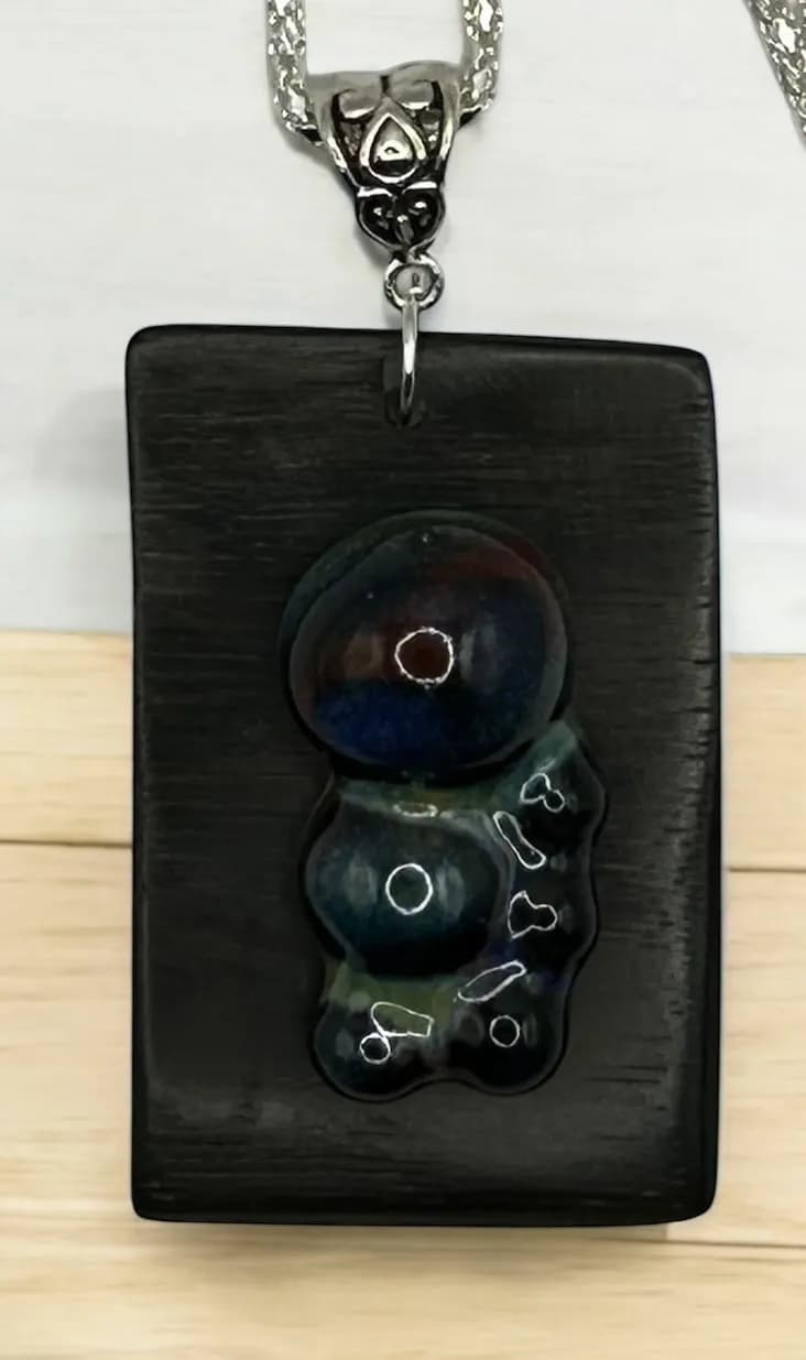 Celestial Harmony: Handcrafted Pendant with Unique Stone Inlay and Elegant Black Wood Base