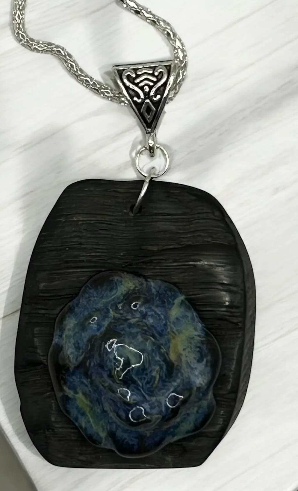 Whispers of the Ocean: Handcrafted Pendant with Blue Swirl Design on Textured Black Base