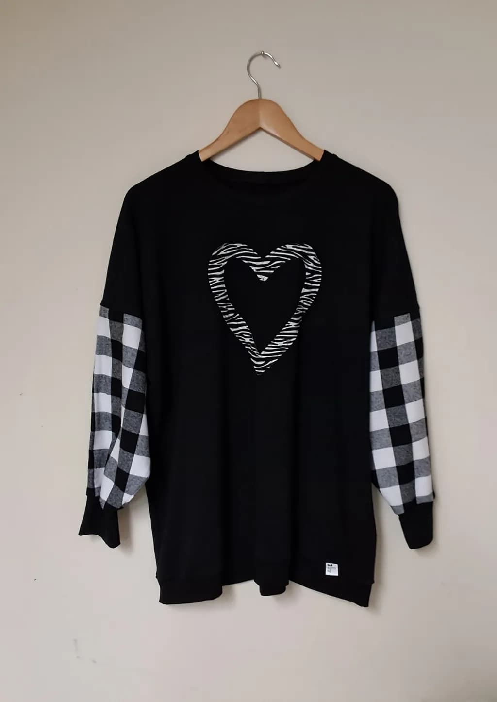 Heartfelt Harmony: Black Sweatshirt with Zebra Print Heart and Checkered Sleeves