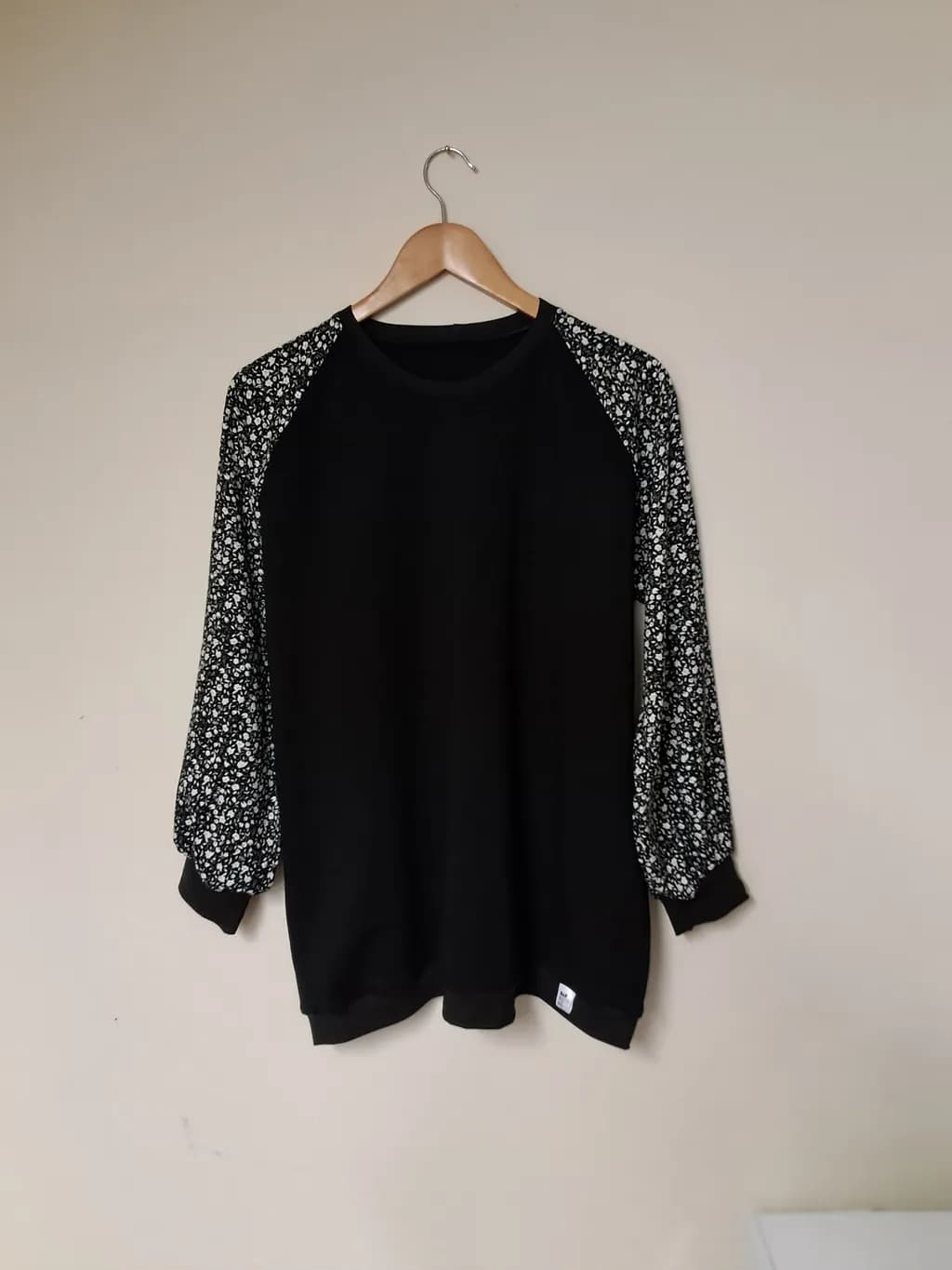Floral Elegance: Black Sweater with Charming Printed Sleeves