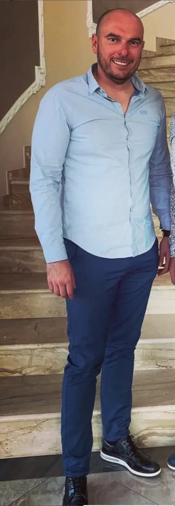 Casual Elegance: A Smiling Man in Blue on the Steps of Life